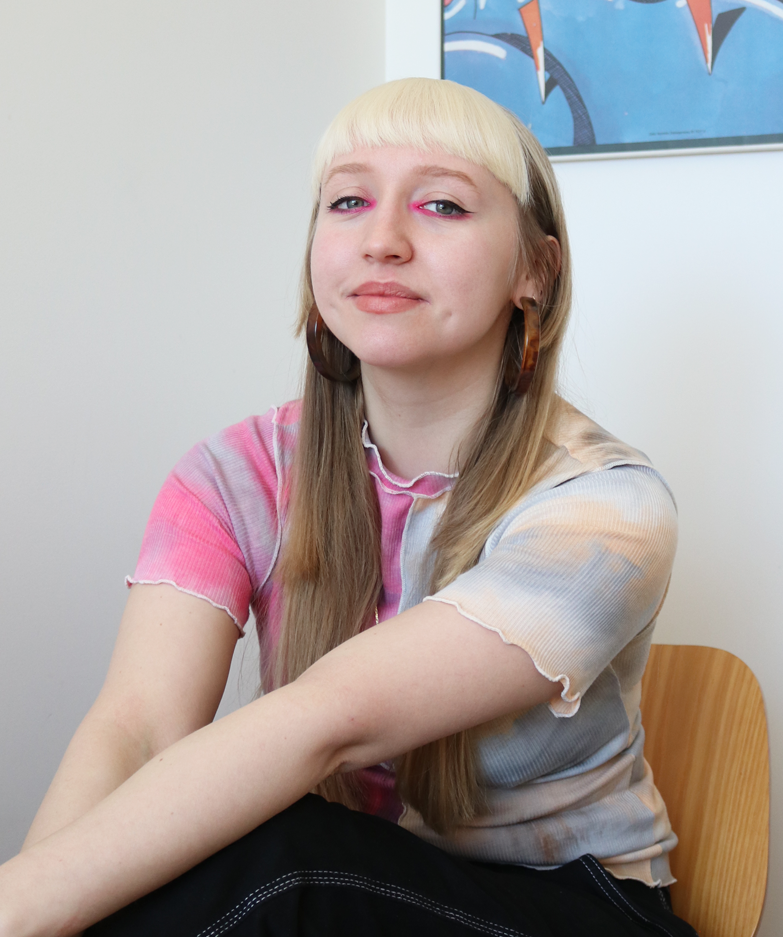 Woman sitting with pink eyeliner, makeup