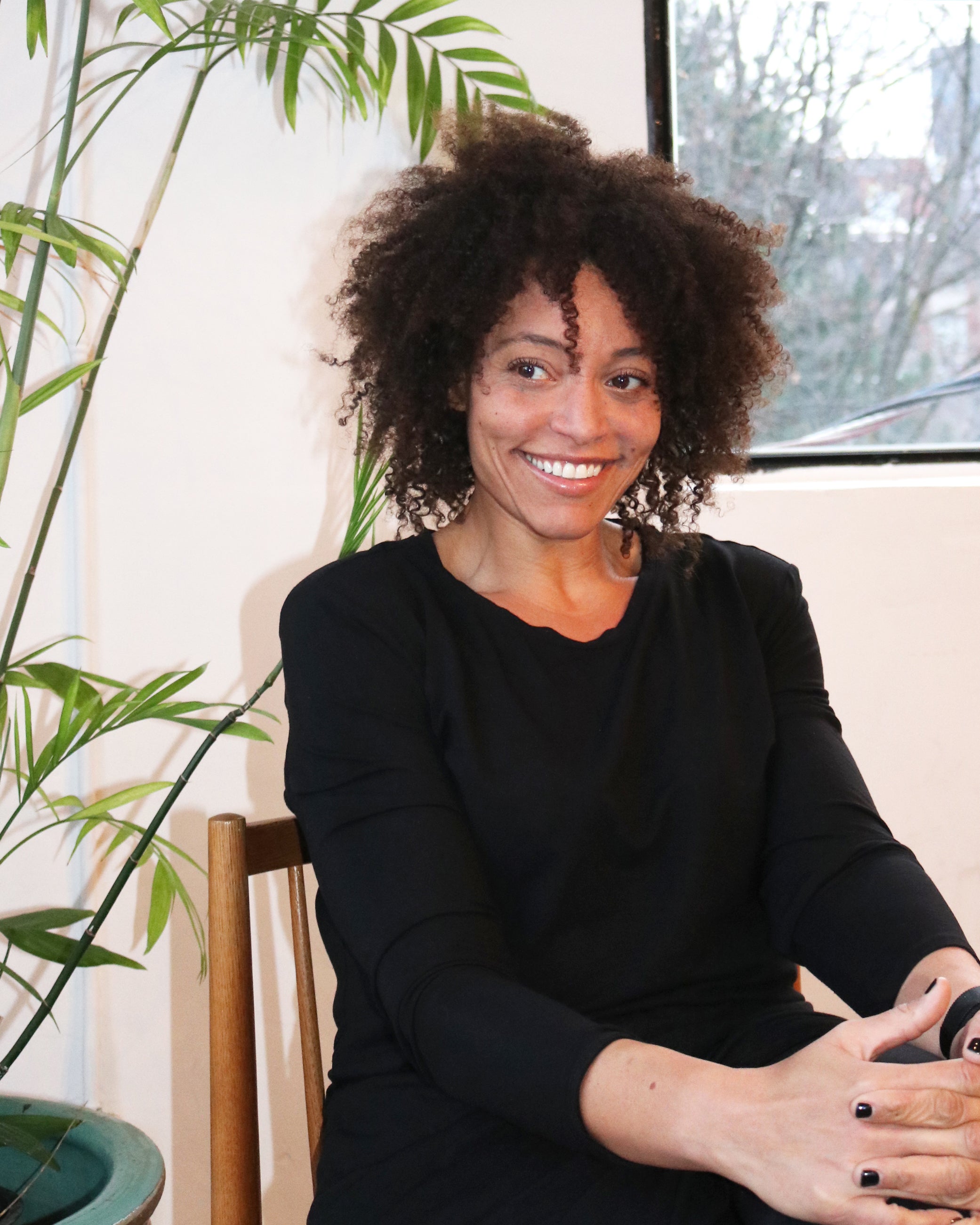 Woman sitting, smiling, makeup